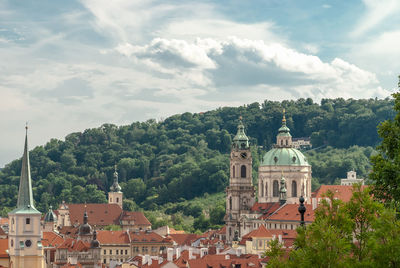 Church and buildings against green mountain