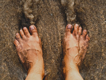 Low section of man on wet sand