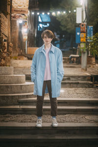 Portrait of young man standing on railroad track