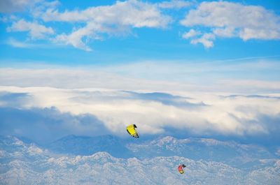 Paragliding over mountain against sky