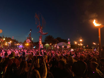 Crowd at music concert against sky at night