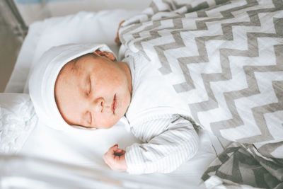 High angle view of cute baby sleeping in bed