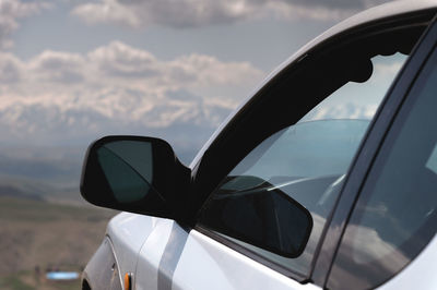 Suv concept with mountains in the clouds. close-up of the nose of the car