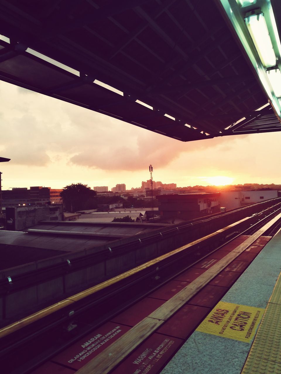 TRAIN AT RAILROAD STATION AGAINST SKY