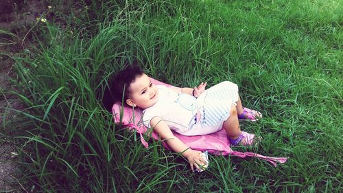 Girl lying on grassy field