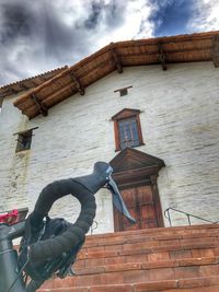 Man on house against sky