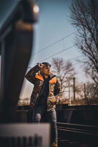 Man looking away while standing against sky