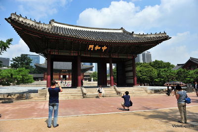 People outside temple against building