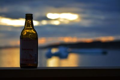 Information sign on table by sea against sky during sunset