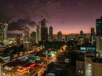 High angle view of illuminated buildings against sky at night