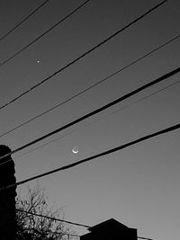 Low angle view of silhouette cables against sky at dusk