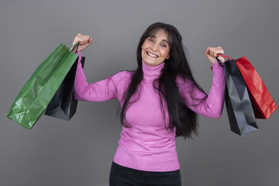 Portrait of young woman holding gift against white background