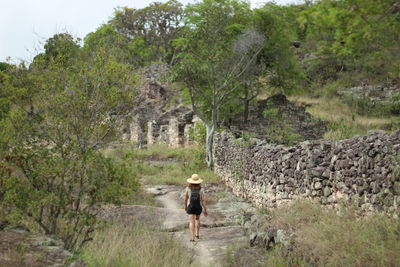 Rear view of woman walking on field
