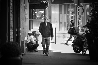 Rear view of people walking on street in city