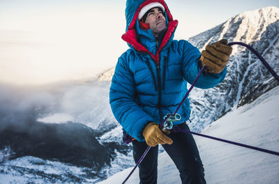 Man with umbrella on snowcapped mountain