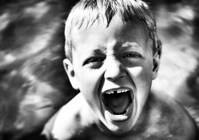 Portrait of boy shouting in swimming pool