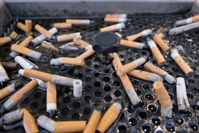 High angle view of wet cigarette butts on ashtray