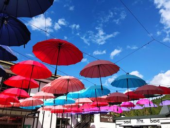 Low angle view of multi colored umbrellas against sky