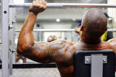 Rear view of shirtless man looking at camera