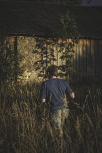 Rear view of man walking on field