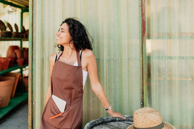 Young female potter entrepreneur looking away while standing in pottery shop