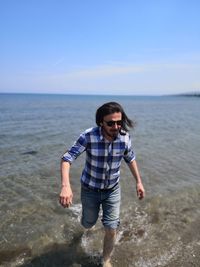 Young man on beach against sky