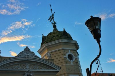 Low angle view of street light by building against sky