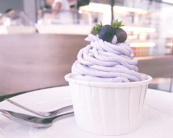 Close-up of ice cream in container on restaurant table