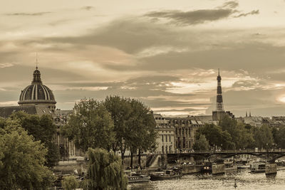 Panoramic view of buildings in city against cloudy sky