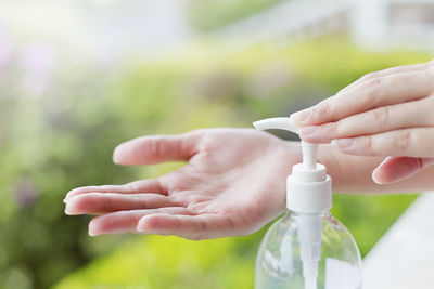 Cropped hands of woman pressing soap dispenser at beauty spa