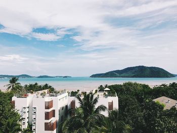 Scenic view of sea by buildings against sky