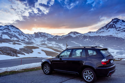 Car on snowcapped mountains against sky during winter