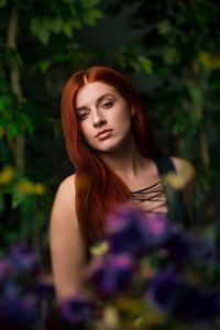 Portrait of young woman against purple tree