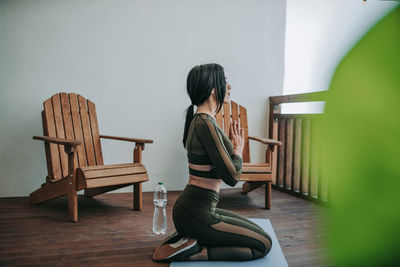 Rear view of woman sitting on chair