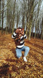 Woman sitting in forest during autumn