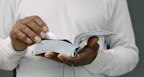 Black man praying to god on gray background with people stock image stock photo