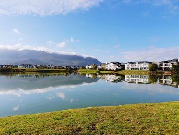 Scenic view of lake by buildings against sky