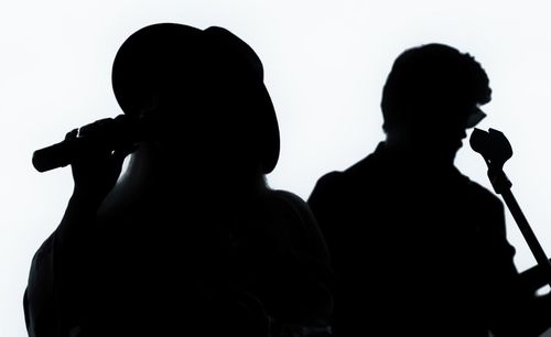 Rear view of silhouette couple against white background