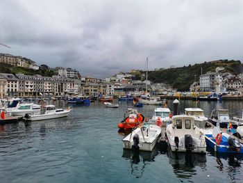 Boats moored in sea against buildings in city