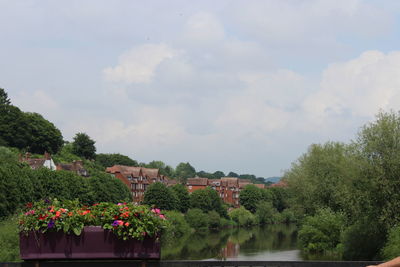 Scenic view of lake by buildings against sky