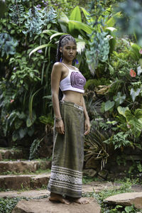 Full length of woman standing against plants