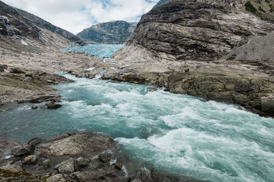 Scenic view of river amidst mountains against sky