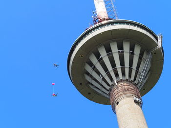 Low angle view of communications tower against blue sky