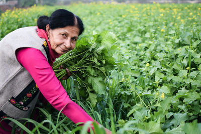 Portrait of a smiling woman picking vegetables