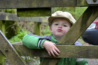 Portrait of cute boy puckering lips by railing