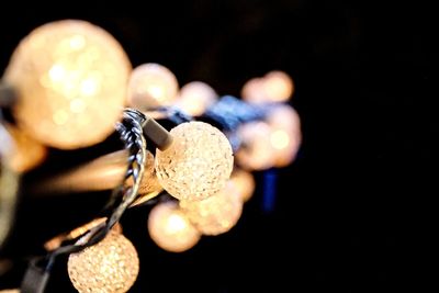 Close-up of illuminated lighting equipment against black background