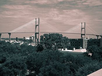 Suspension bridge against cloudy sky