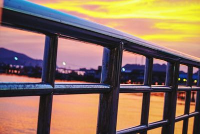 Close-up of railing against sky during sunset