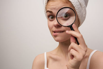 Portrait of smiling woman looking through magnifying glass