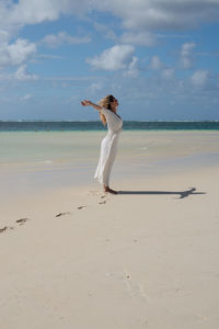 Woman standing with arms outstretched standing at beach